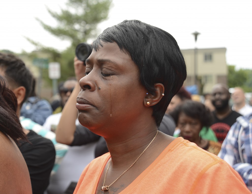 Participant in August 16 rally as she listens to Rev. Jesse Jackson. Photo by ELLEN DAVIDSON