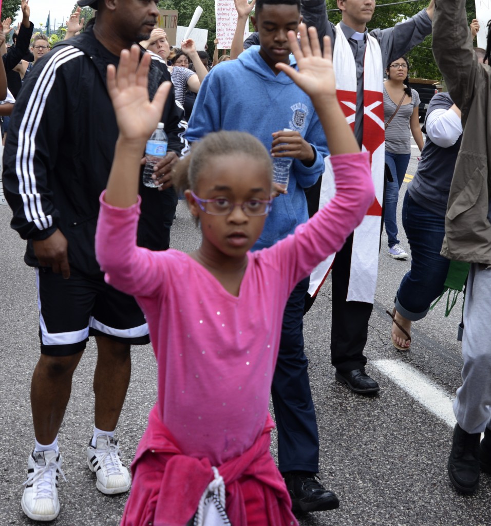 Young marcher shows her "Hands up, don't shoot!" technique. Photo by ELLEN DAVIDSON