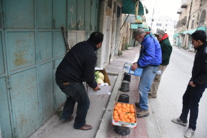 Setting up a makeshift vegetable stand on Hebron's Shuhada Street. PHOTO: ELLEN DAVIDSON